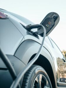 Detailed view of an electric car plugged into a charging station outdoors.